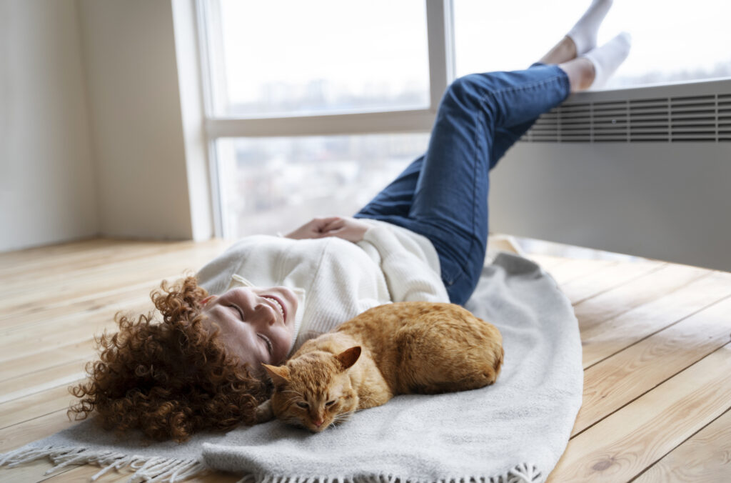full-shot-woman-cat-laying-blanket-1024x676