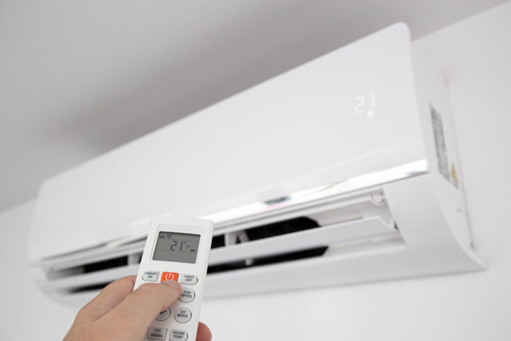 hand-operating-remote-control-domestic-air-conditioner-unit-mounted-wall-lj5obzhs-1024x683